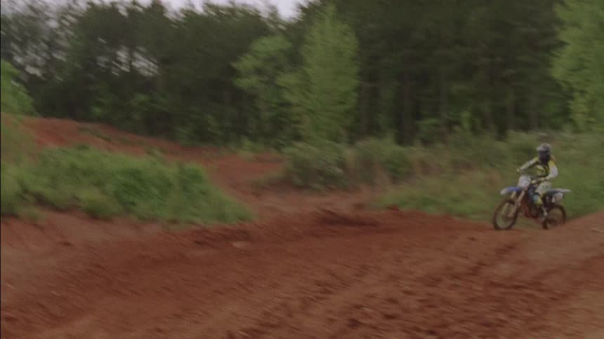 The dirt bikes are racing jumping over the hills