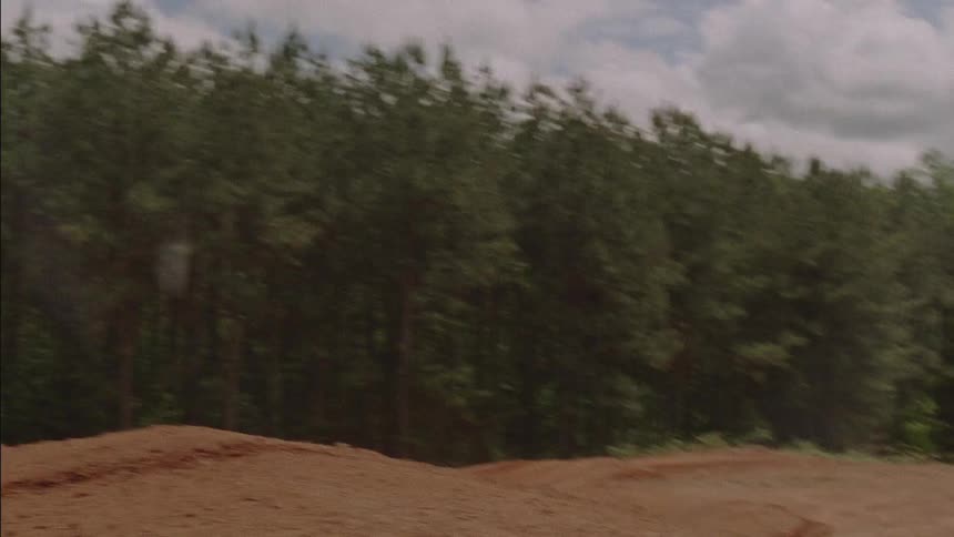 Riders go over a bump in a dirt track on motorbikes