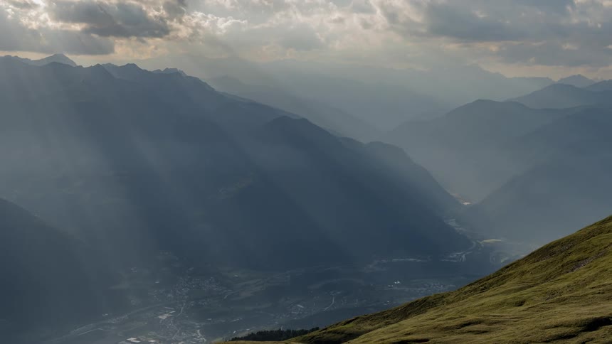 Sunlight streams through clouds in the mountains