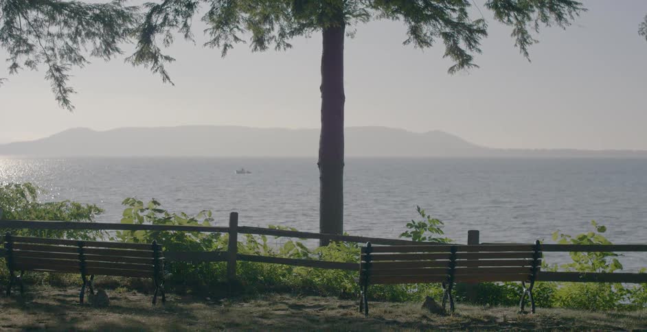 A boat is floating off the coast on a hazy day