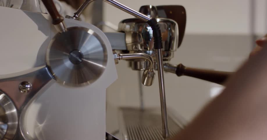 A person operates a coffee machine