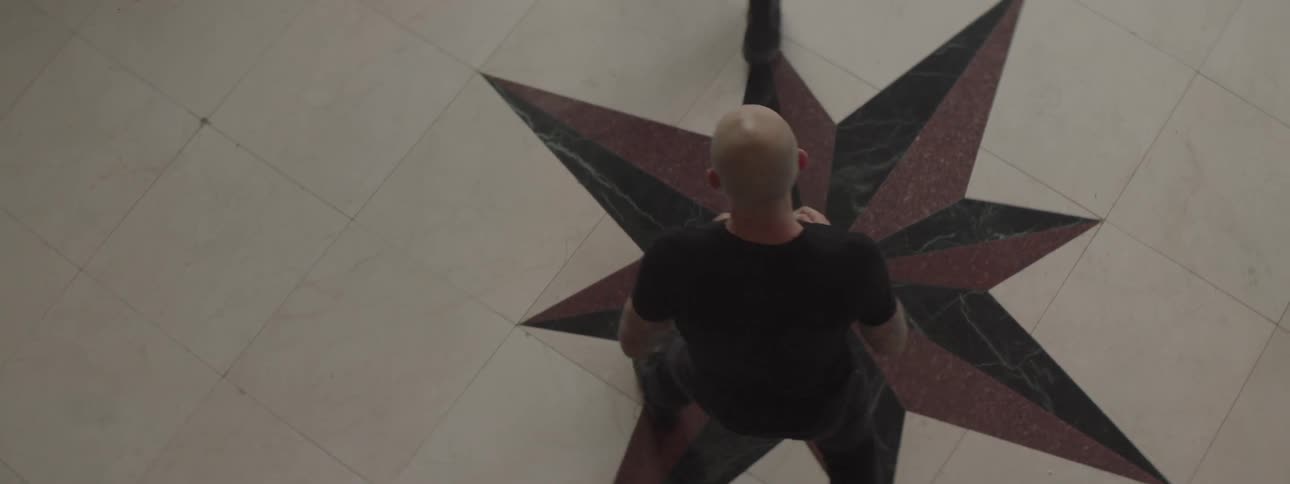 Two men fight on a floor painted with a star
