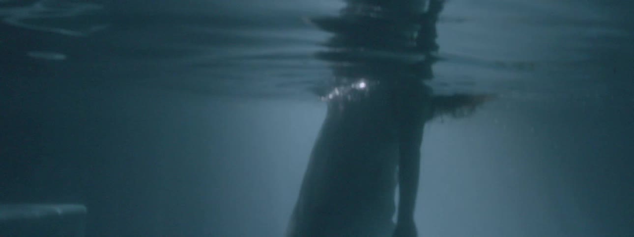 A woman falls down under the water and tries to swim to the surface repeatedly