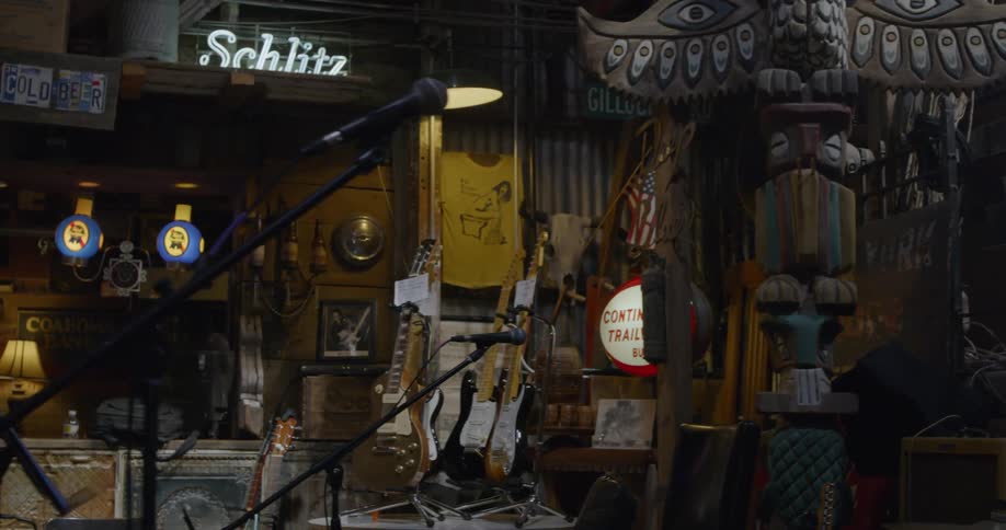 A bar with a lot of decorations and two microphones on stage