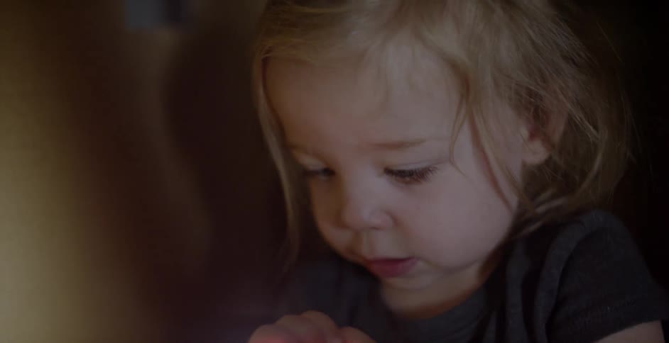 A child plays with a light in the dark room