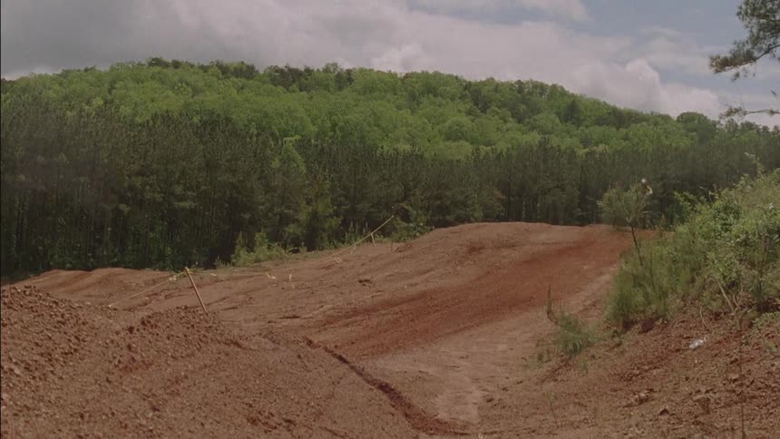 People go over jumps on dirt bikes