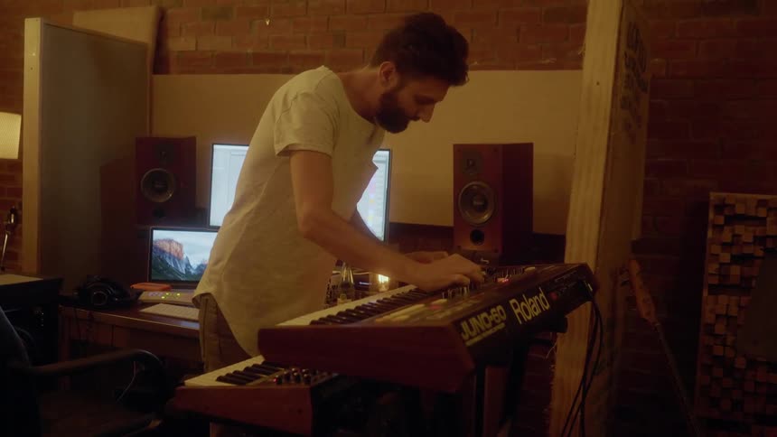 A man is using a keyboard in a studio