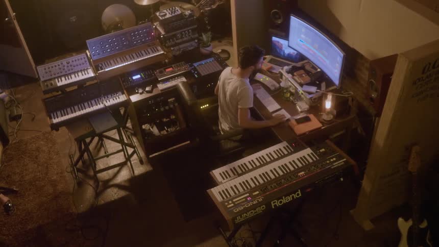 A man works surrounded by keyboards