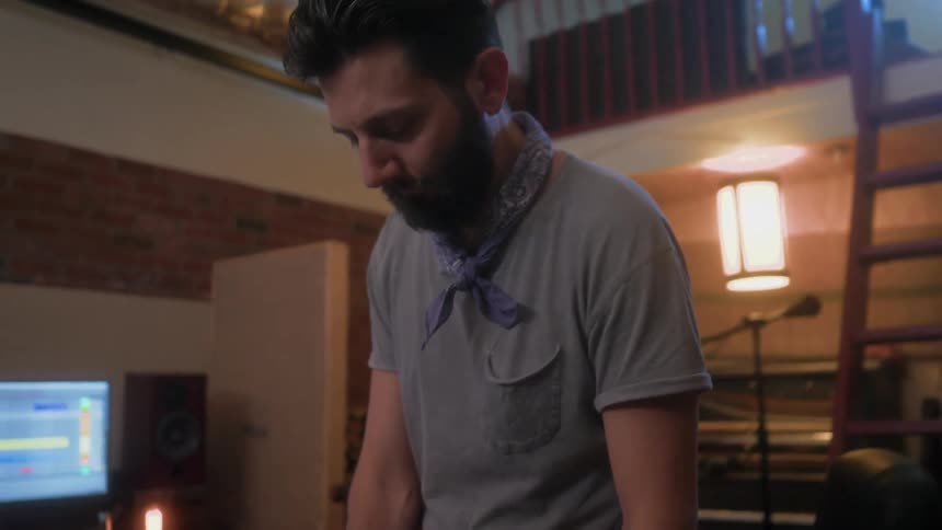 Man works on something while he stands near a computer