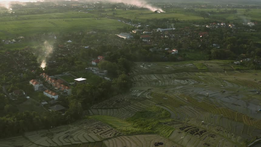 Smoke roses from a rural landscape