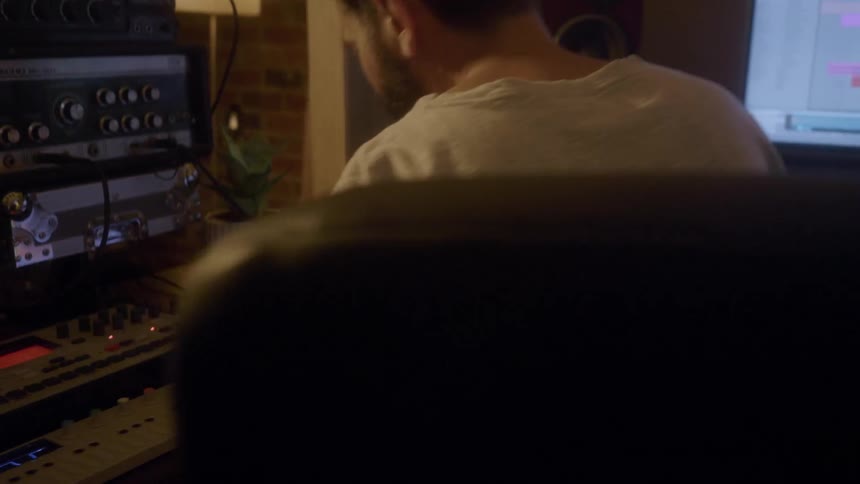 A man is working on computers in his studio