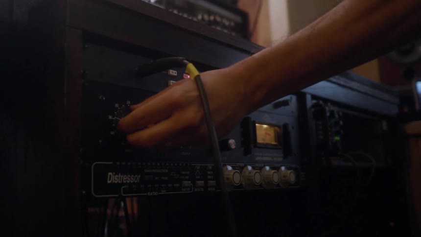 A person is turning knobs on a stereo