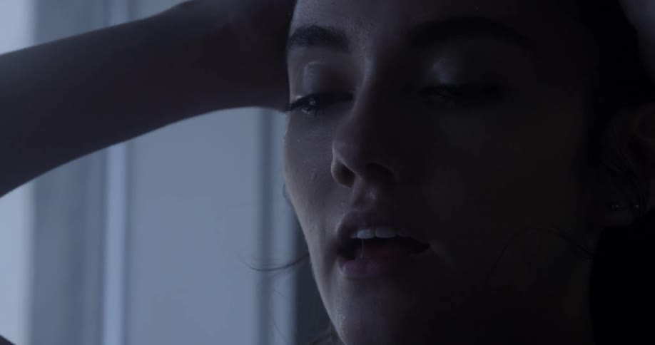 A woman looks worried as she pulls her hair back