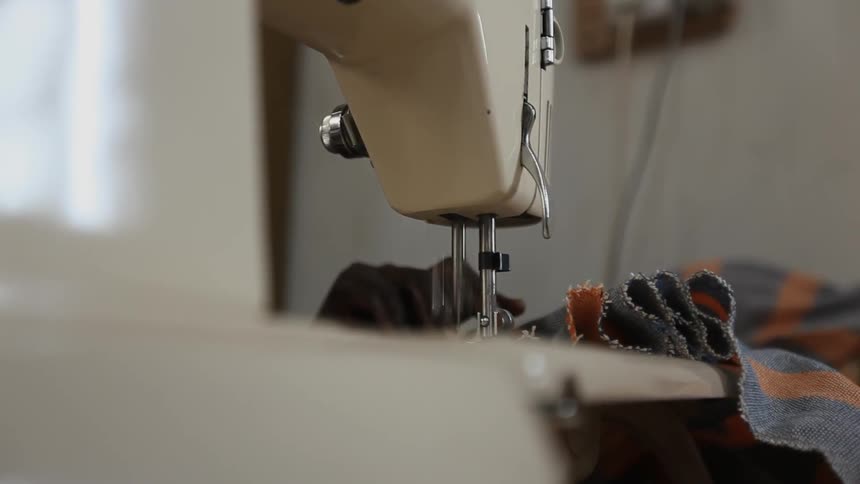 A person uses a sewing machine
