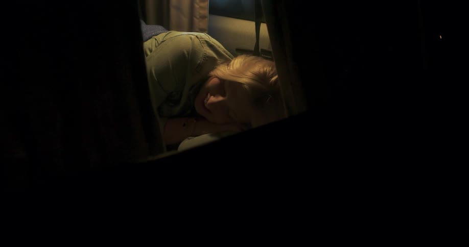 A woman lays and smiles on a bed