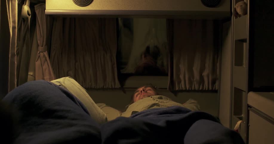 A man smiles at the person in his bed