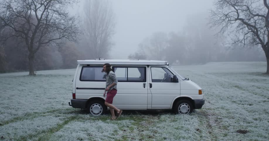 A man exits a white van in the snow