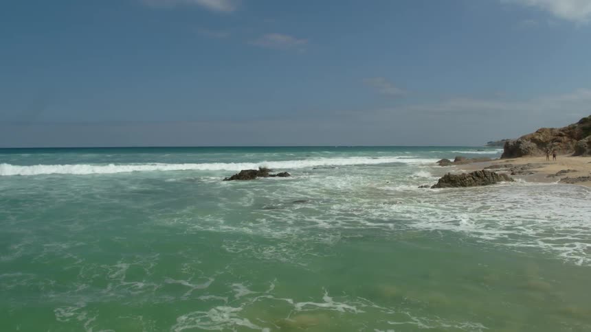 Ocean waves wash ashore a sandy beach