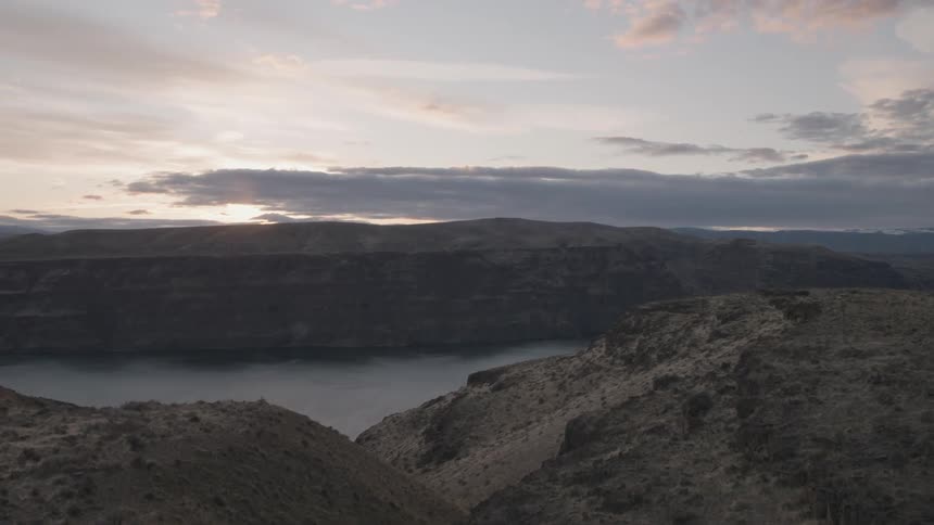 Flying over rugged cliffs that drop down into a vast river gorge