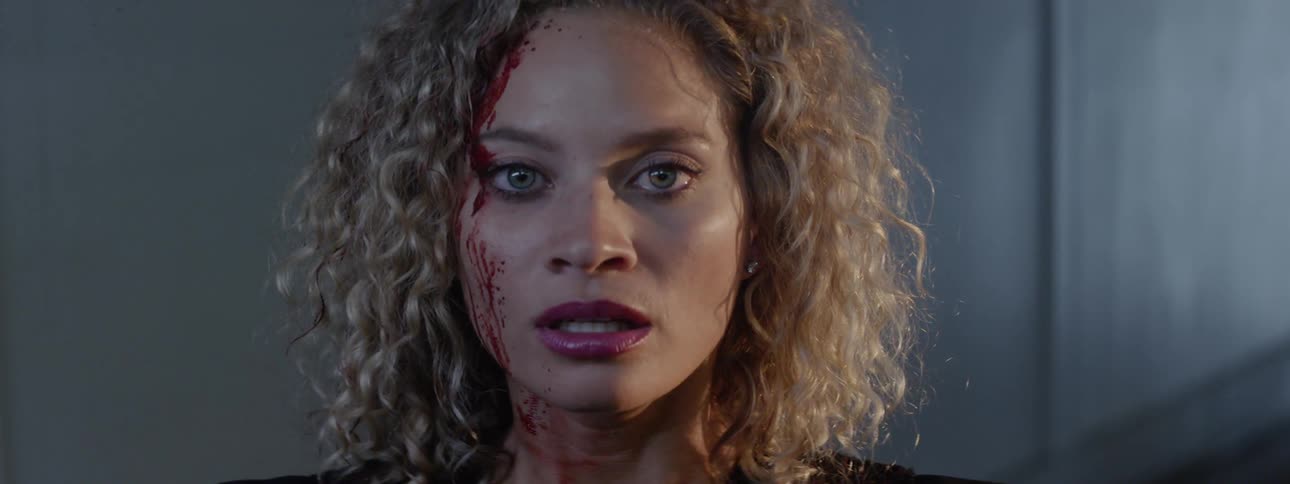 A woman looks scared with blood on her face