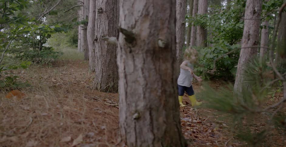 A girl wearing boots walks in the woods