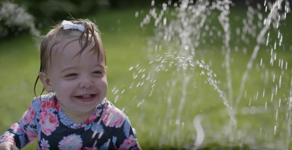 A child is having fun playing in the fountain water