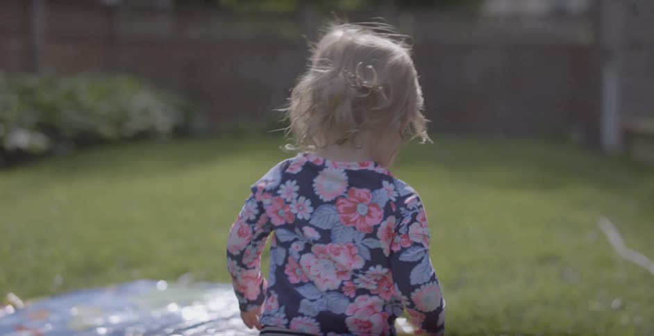 A child walks around in the yard