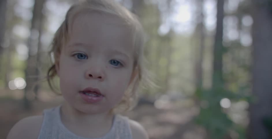 A child looks forward bobbing her head