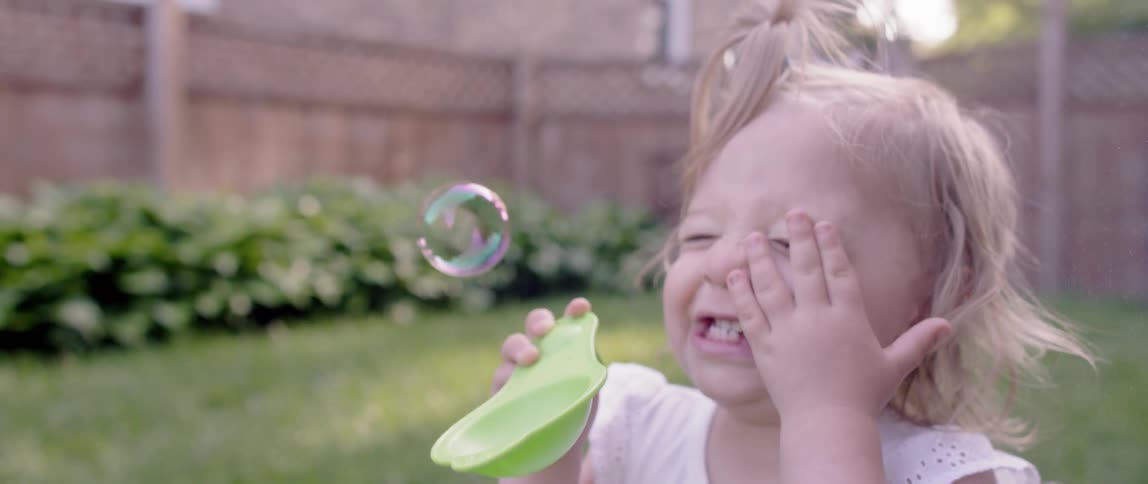 A bubble pops on a toddler's face