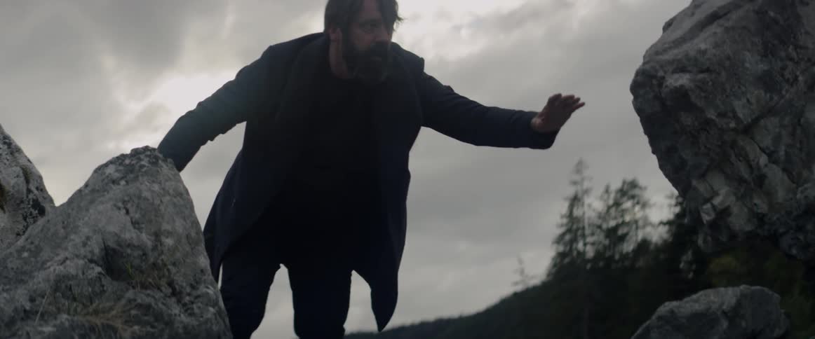 A man crawls over the rocks