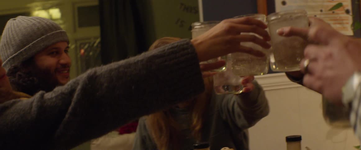 A group of people toast with mason jars