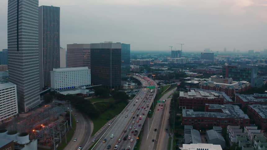 Traffic flows on a freeway in a city at dusk