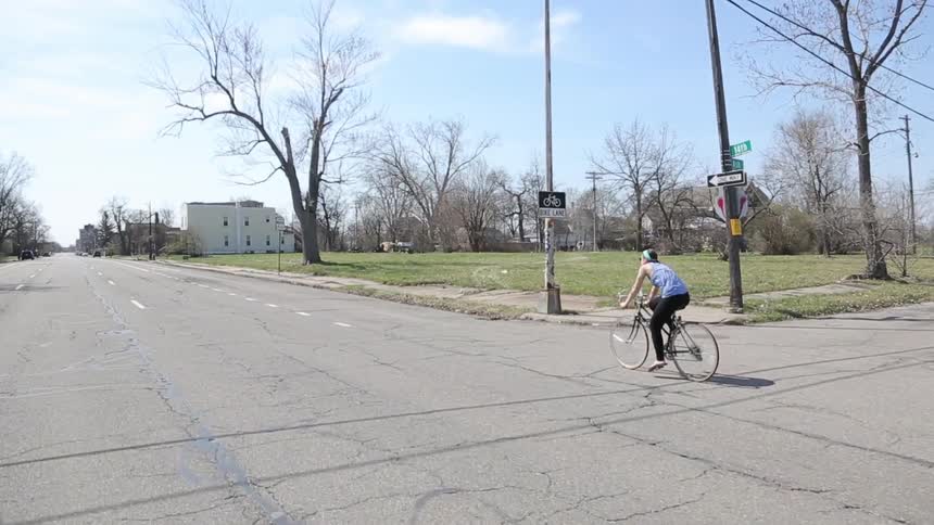 A bicyclist pedals down a rural road