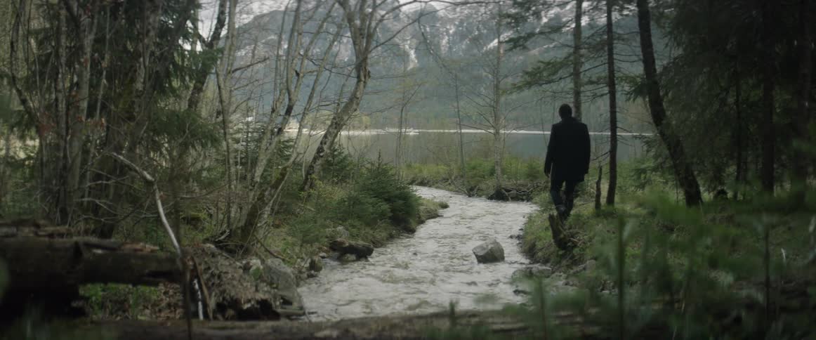 A man walks beside a river