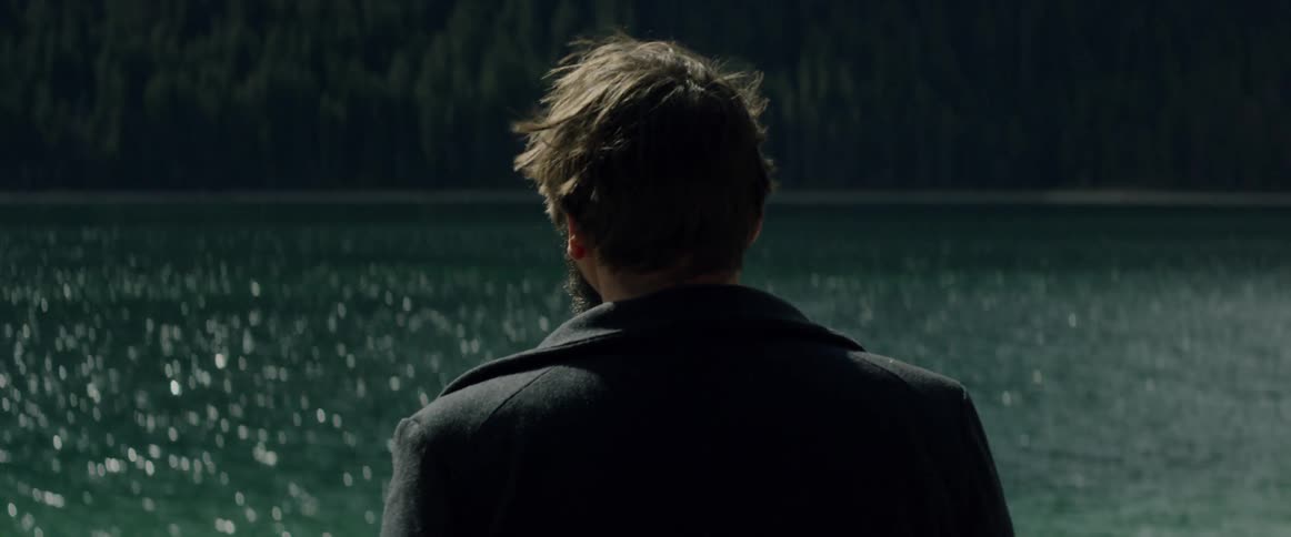 Man looks out across the sparkling water