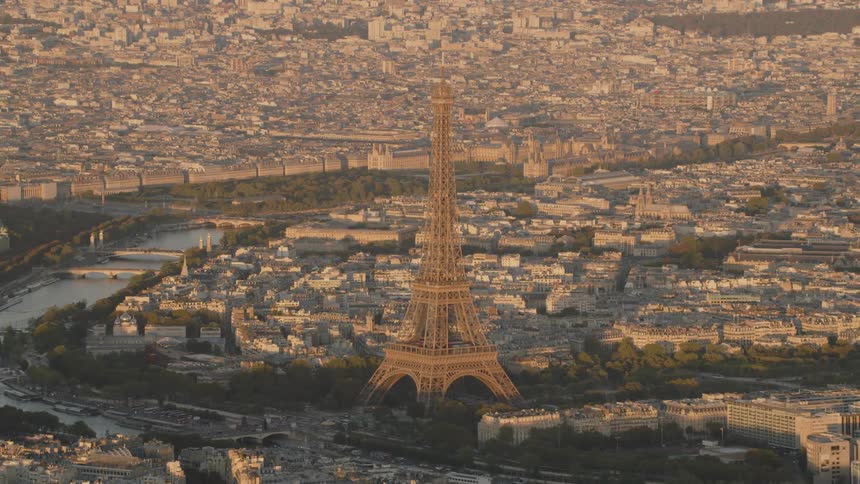 The eiffel tower stands tall above the other city buildings near the canal
