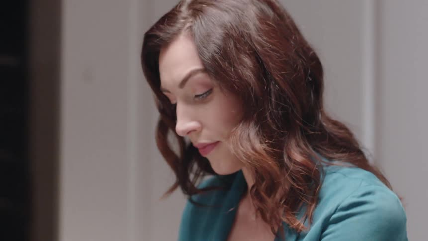 A woman is looking down going through papers