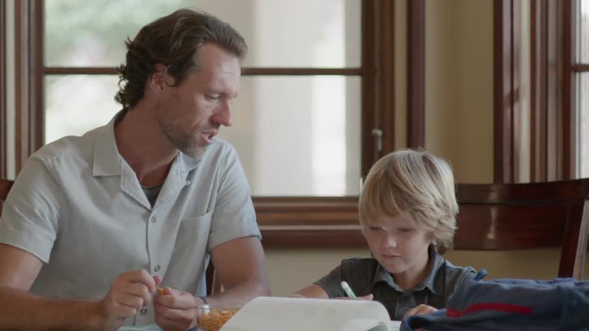 Man and boy doing homework at the table