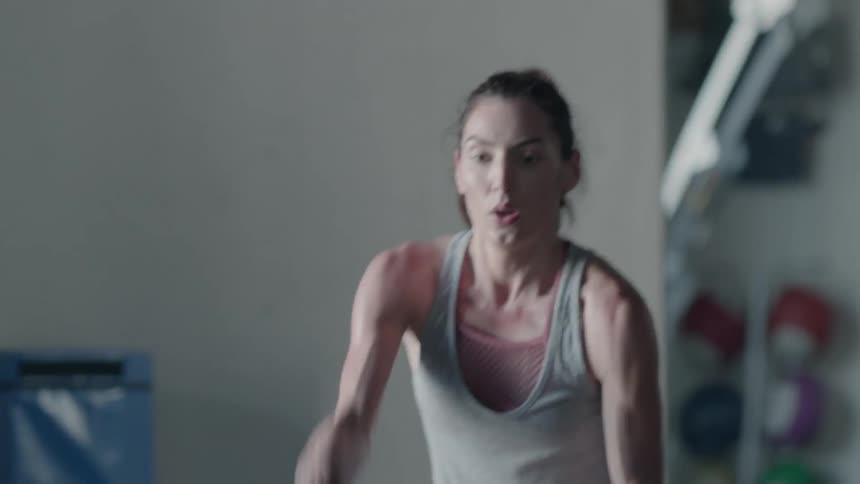 Woman exercises by hitting ropes on the floor