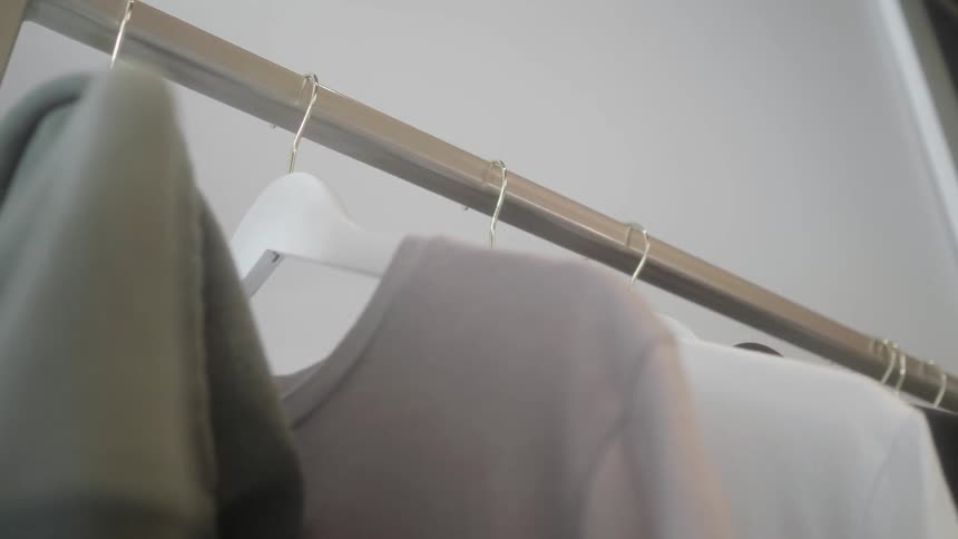 Clothes hang from a metal bar