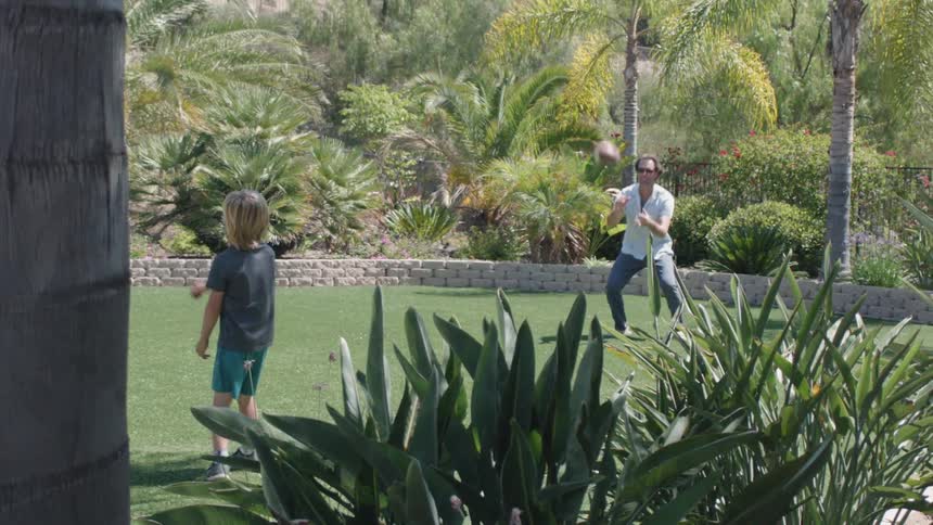 Man and boy toss football back and forth to each other