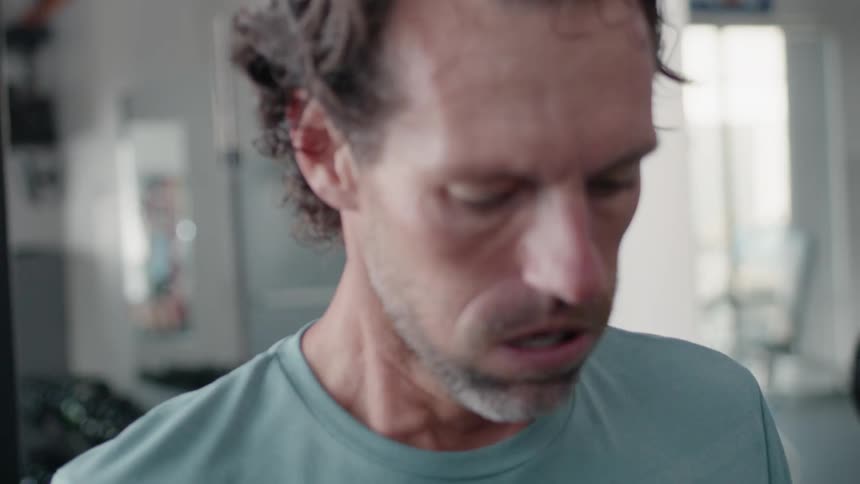 A man catches his breath in a gym