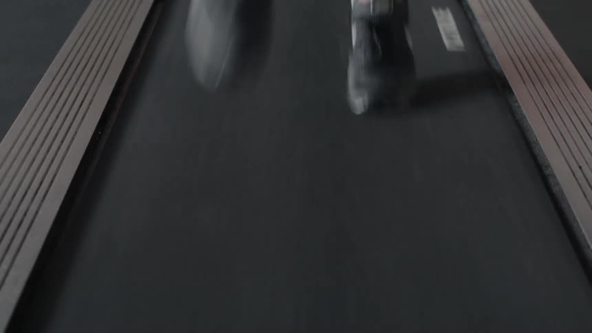 A person wearing sneakers runs on a treadmill