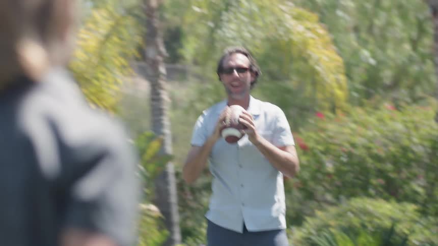 Two people are throwing a football back and forth