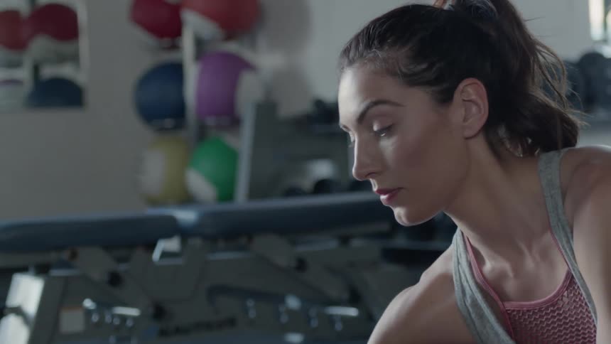 A woman stretches at the gym