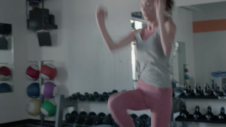 Woman jogs in place in a gym