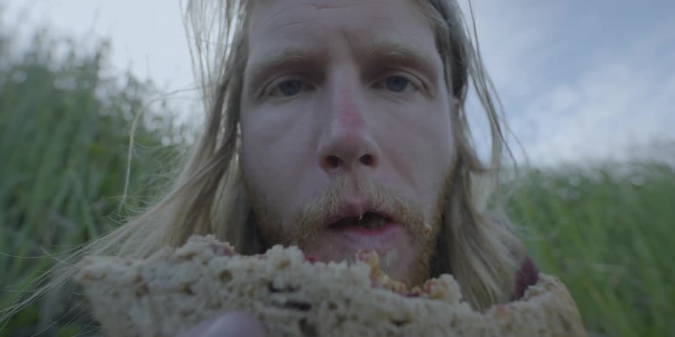 A man eats a sandwich outside