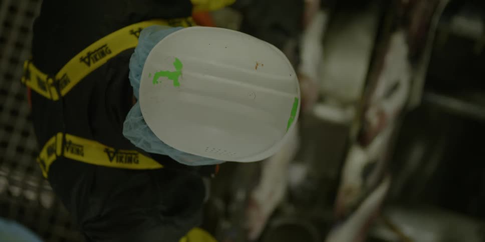 An overhead view of a man with a hardhat on working
