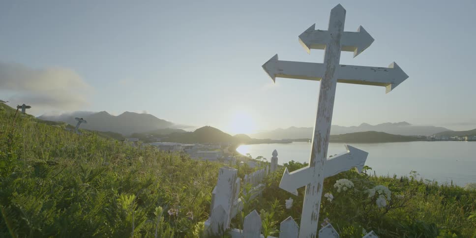 Grave marker near a shore at sunset