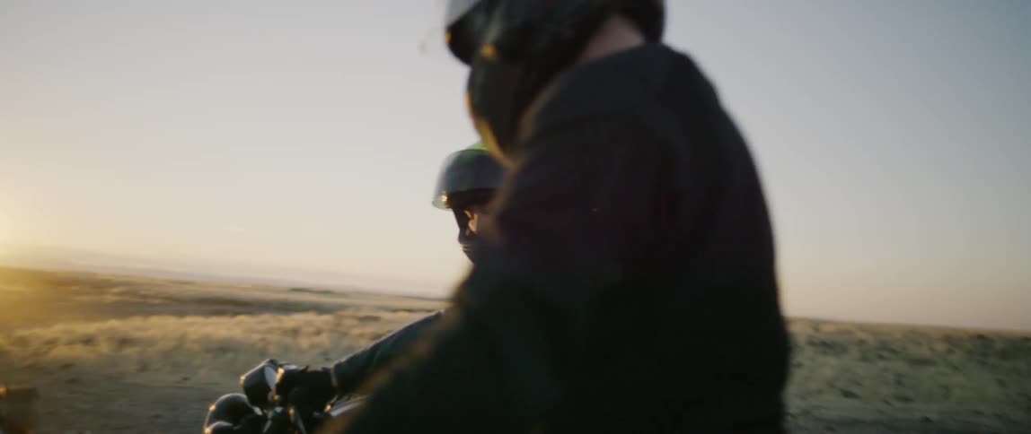 Two people ride motorcycles together